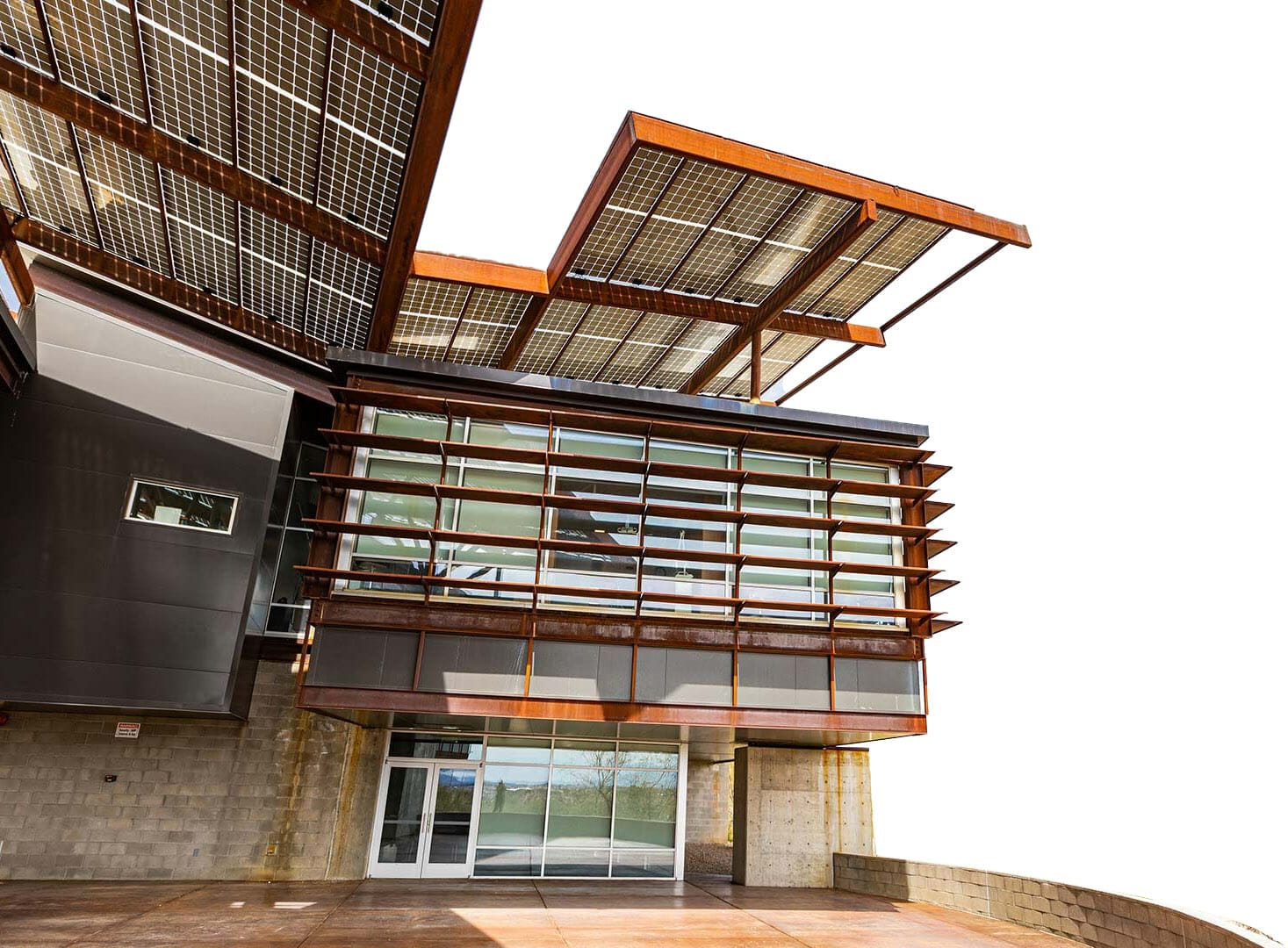 Exterior of Sleep Perfection Office with large solar panel overhangs and a glass facade featuring horizontal sunshades