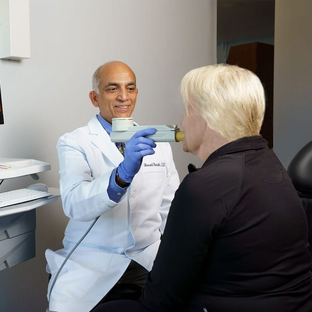 Dr. Pandhi using oral testing device on a patient
