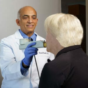 Dr. Pandhi evaluating patient with blonde hair