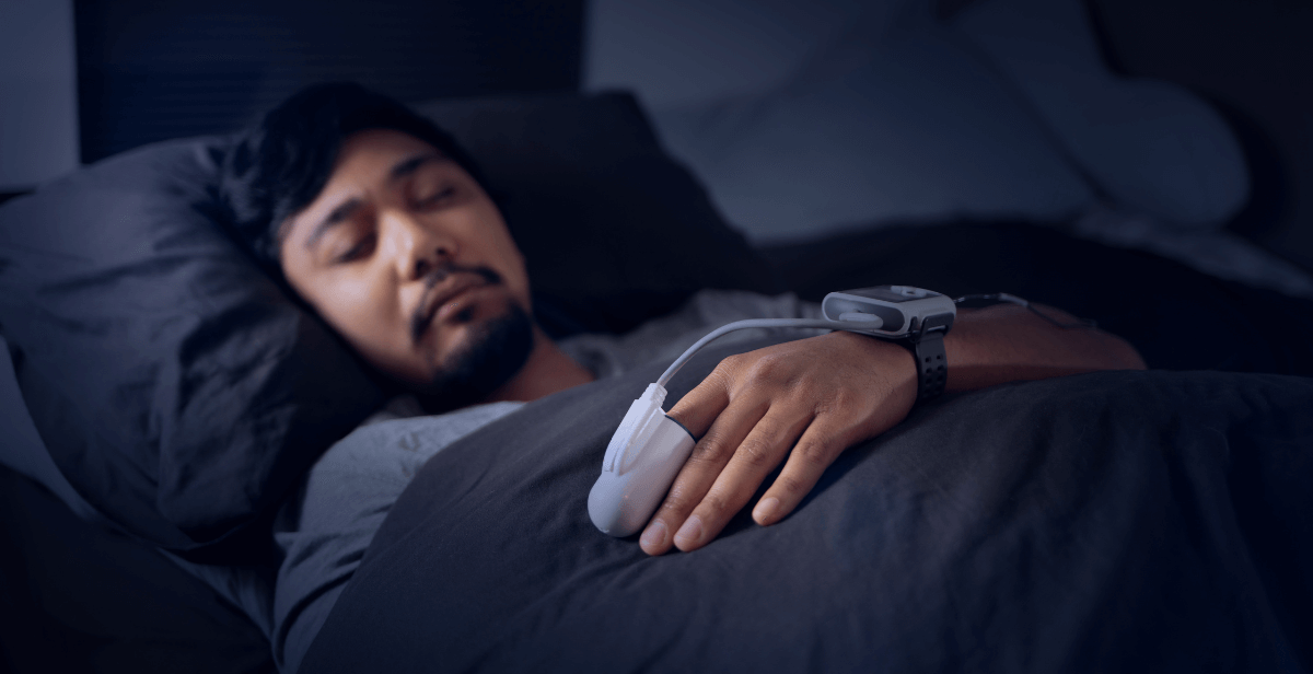 man sleeping with device on index finger