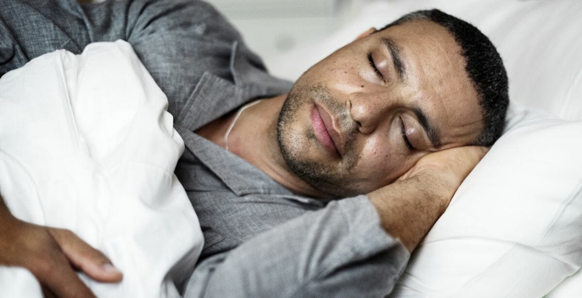 man sleeping in gray pajamas