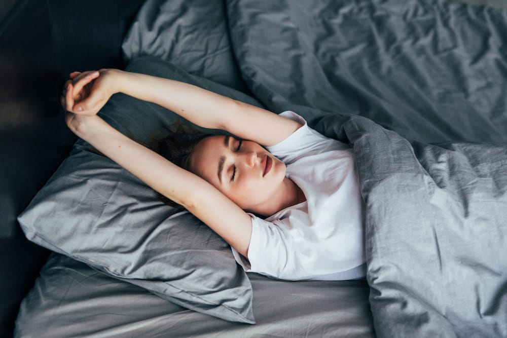 Woman stretching in bed after a restful night’s sleep