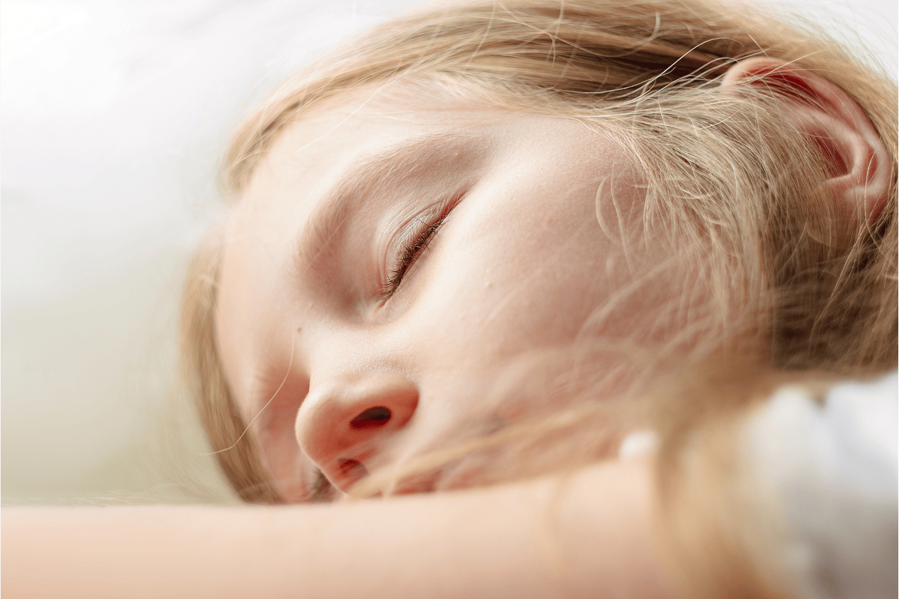 A close-up of a young child sleeping peacefully with eyes closed
