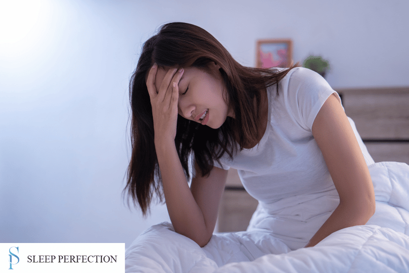 Woman in bed with morning headache linked to sleep apnea and teeth grinding